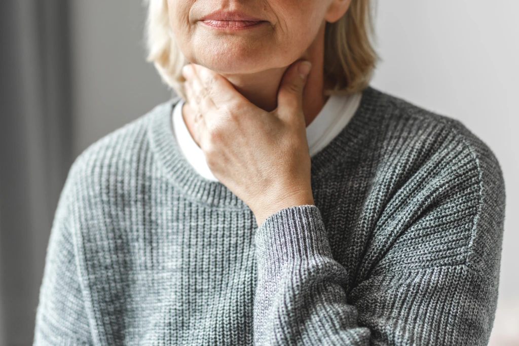 Frau tastet die Lymphknoten am Hals